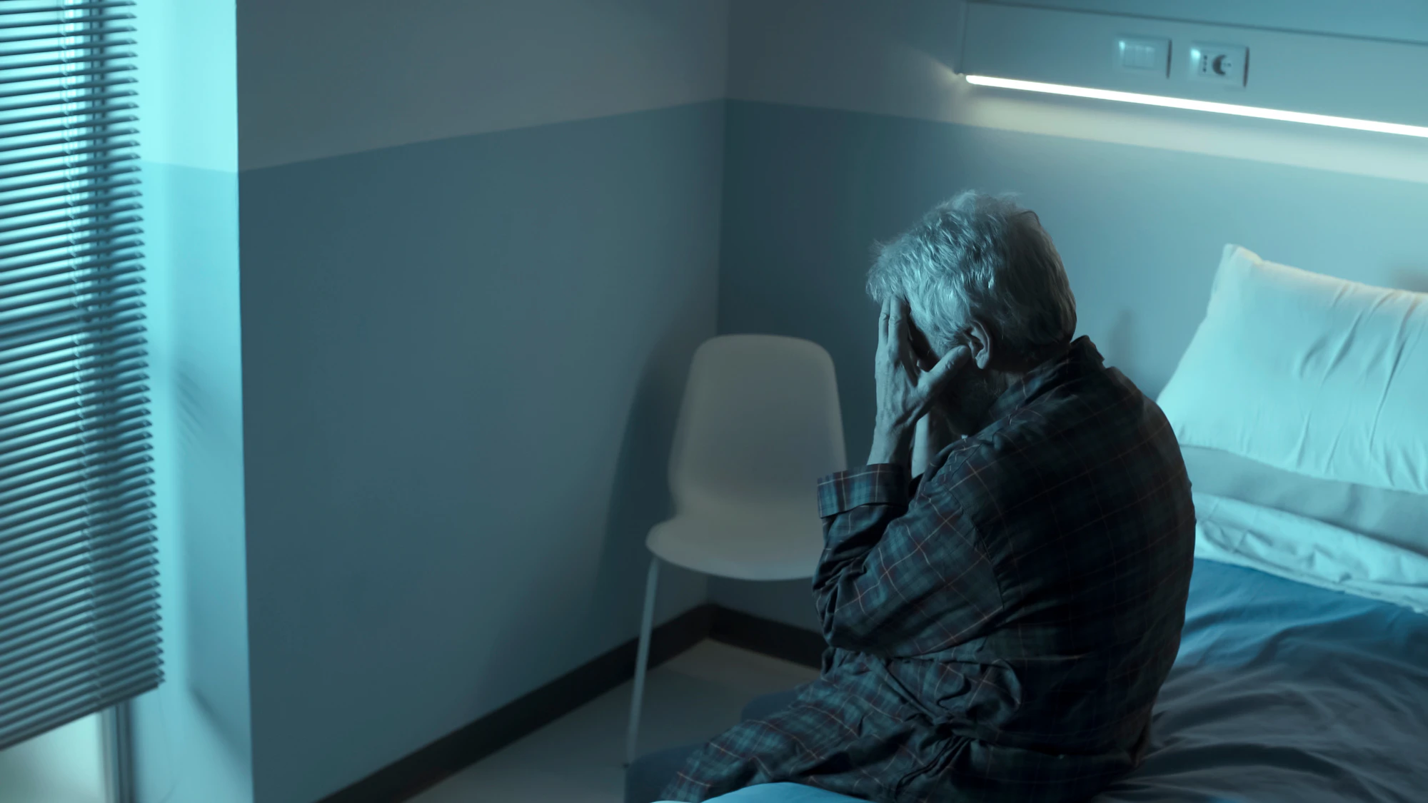 man not sleeping in hospital bed
